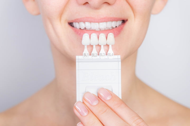Woman holding a tooth shade guide - Opalescence Teeth Whitening in St. George, UT Woman holding a tooth shade guide - Opalescence Teeth Whitening in St. George, UT