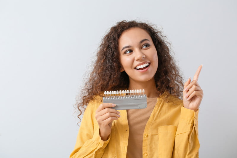 Woman holding a tooth shade guide - Cosmetic Dentistry in St. George, UT